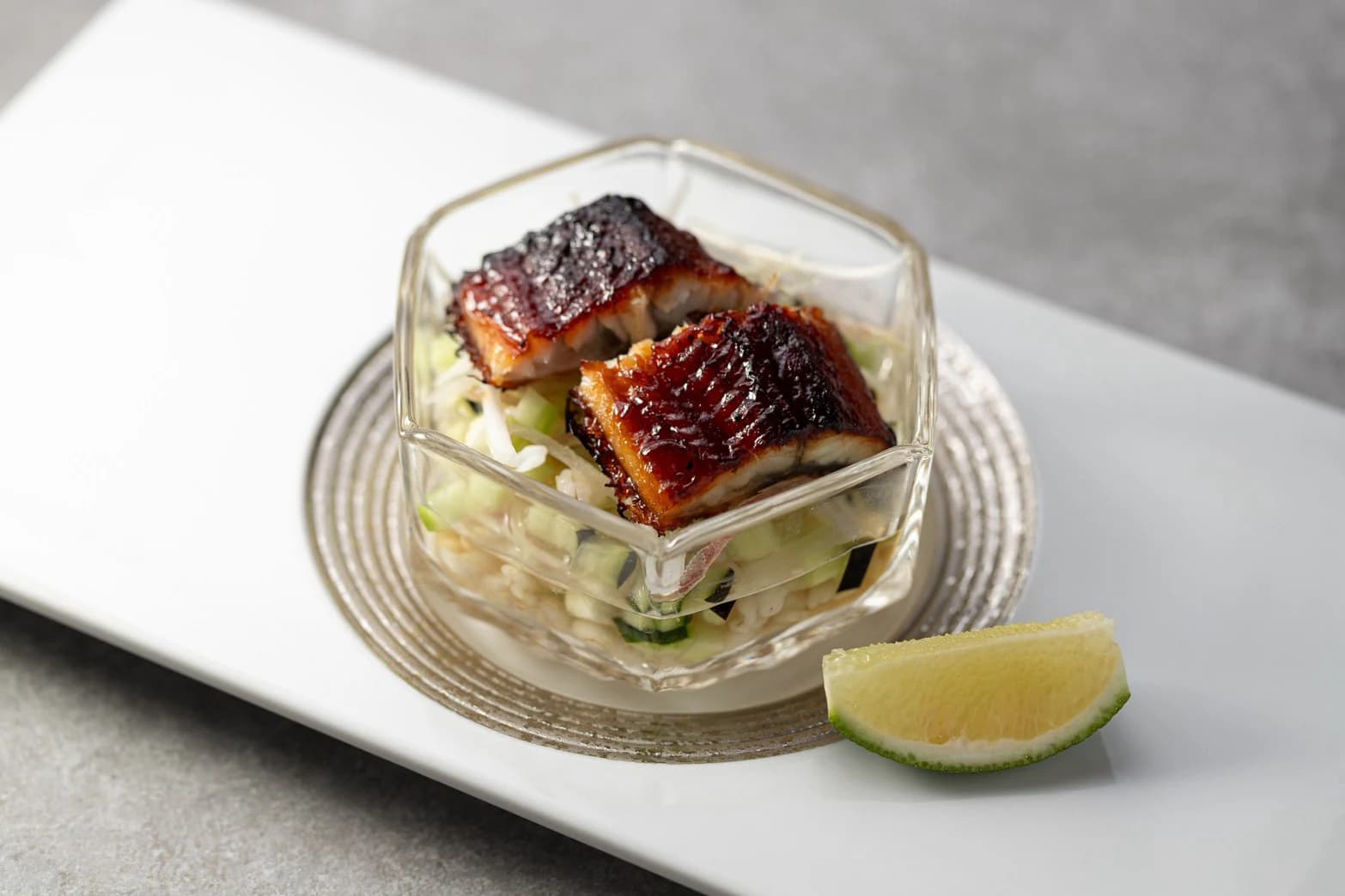 香ばしく焼いた魚を野菜の和え物にのせ、ガラスの器に盛った一品