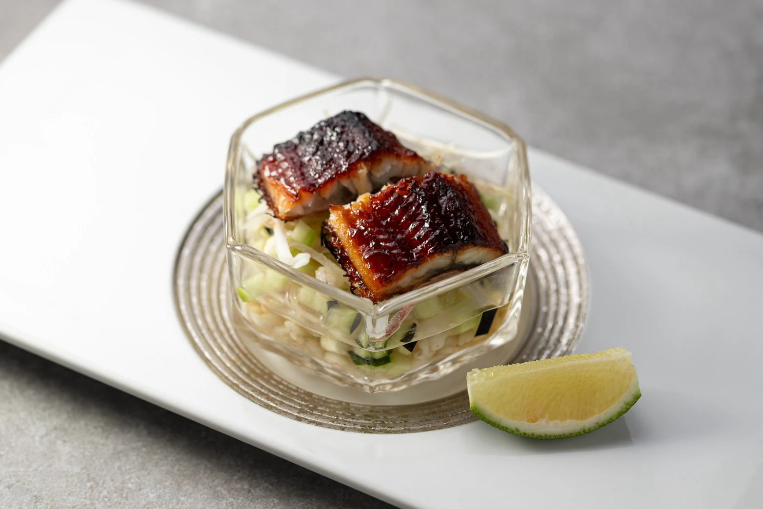 香ばしく焼いた魚を野菜の和え物にのせ、ガラスの器に盛った一品